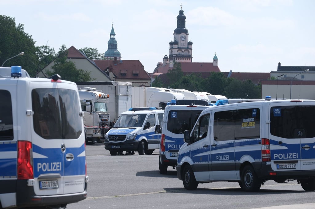 Polizisten versammeln sich auf einem Parkplatz.