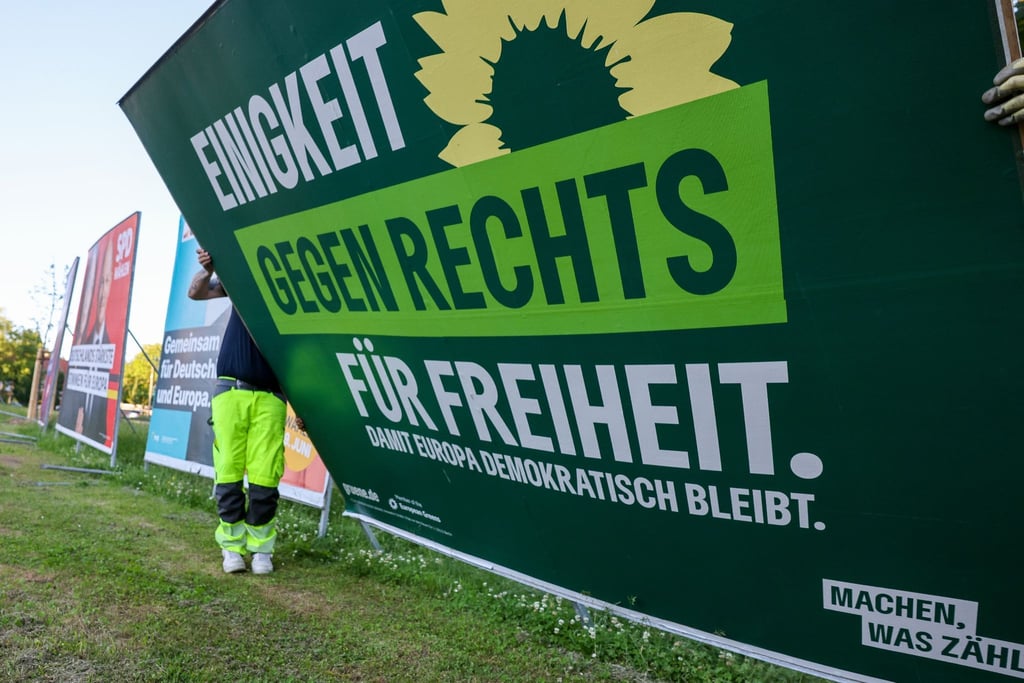 Zwei Mitarbeiter einer Firma für Werbeaufsteller bauen ein Wahlplakat der Partei „Bündnis 90/Die Grünen“ nach der Europawahl ab. Die Europawahl begann am 6. Juni.