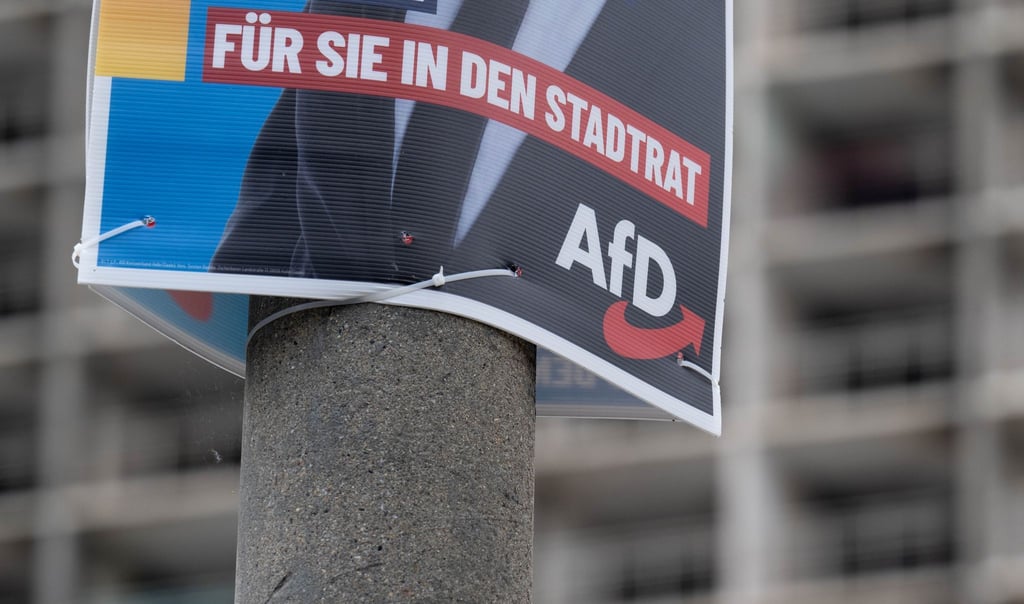 Ein Wahlplakat der AfD zur Kommunalwahl hängt vor einem Neubaublock in Halle.
