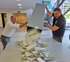 Der stellvertetende Wahlvorstand Lars Pietschmann (links) und Wahlvorstand Ronny Tangel haben die Stimmzettel im Wahllokal in der Weißenfelser Stadthalle gemeinsam ausgeschüttet, um die Stimmen zu zählen.