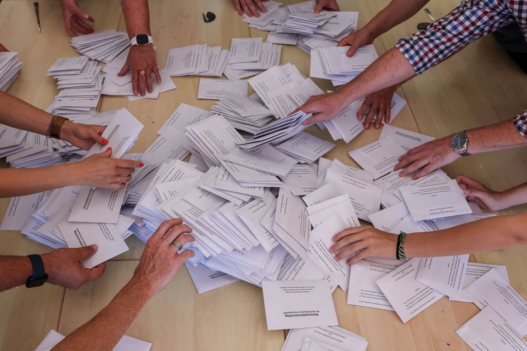 Zahlreiche Wahlhelfer nehmen sich bei der Stimmenauszählung die Umschläge mit den Briefwahlstimmen zur Europawahl.