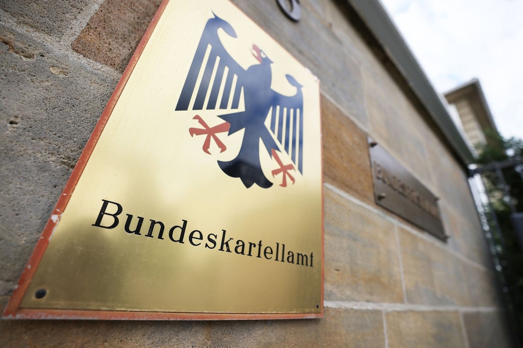 Ein Schild mit Bundesadler hängt vor dem Bundeskartellamt in Bonn.