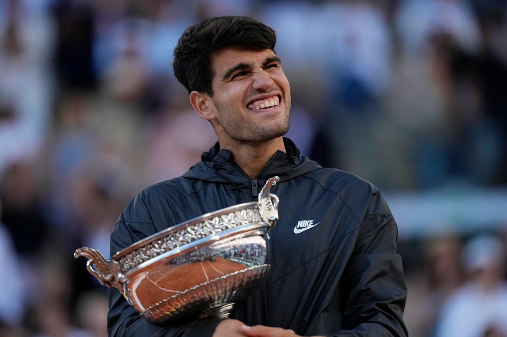 Carlos Alcaraz feiert mit der Trophäe nach seinem Sieg.