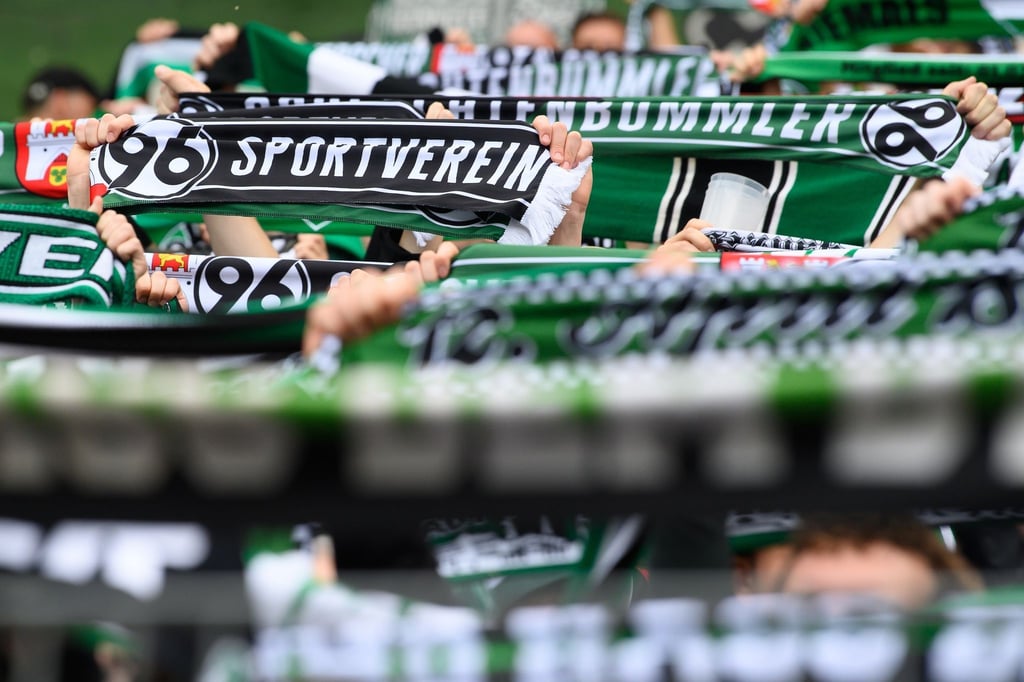Hannovers Fans stehen mit ihren Schals auf der Tribüne.