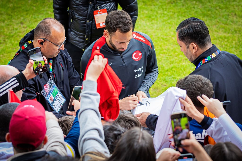 Der Türke Hakan Calhanoglu (M) gibt beim öffentlichen Training Autogramme.
