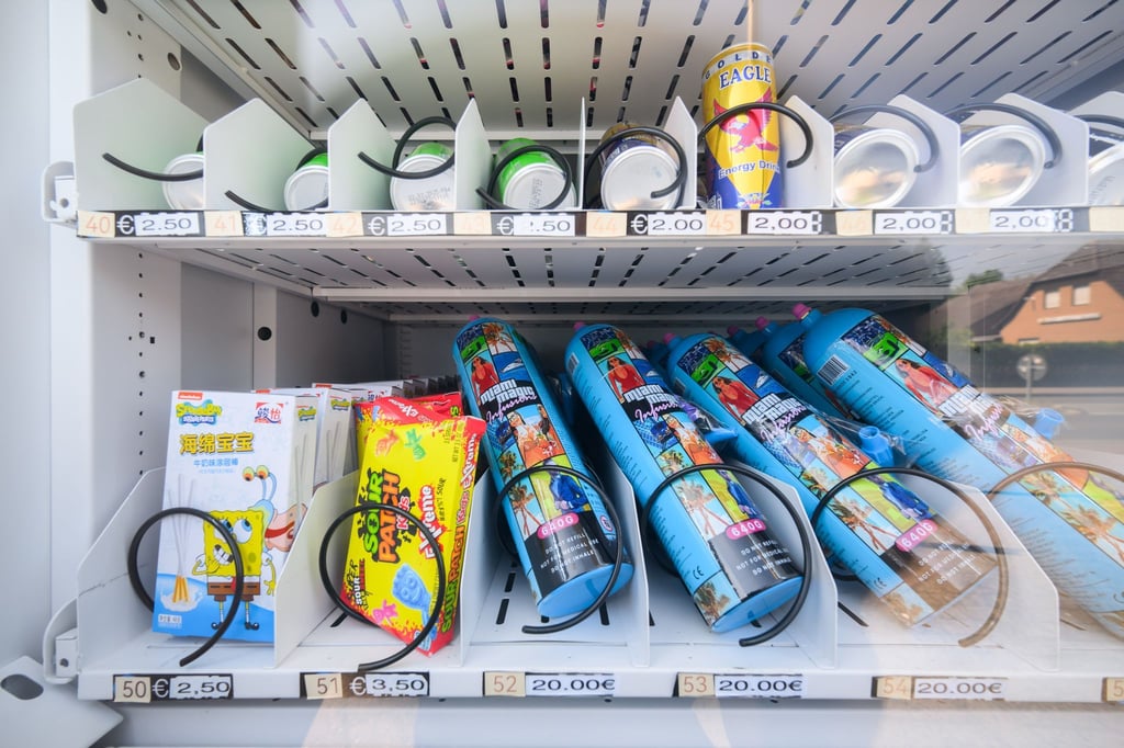 Ein Warenautomat, unter anderem mit Lachgasflaschen bestückt, steht vor einem Ladengeschäft.