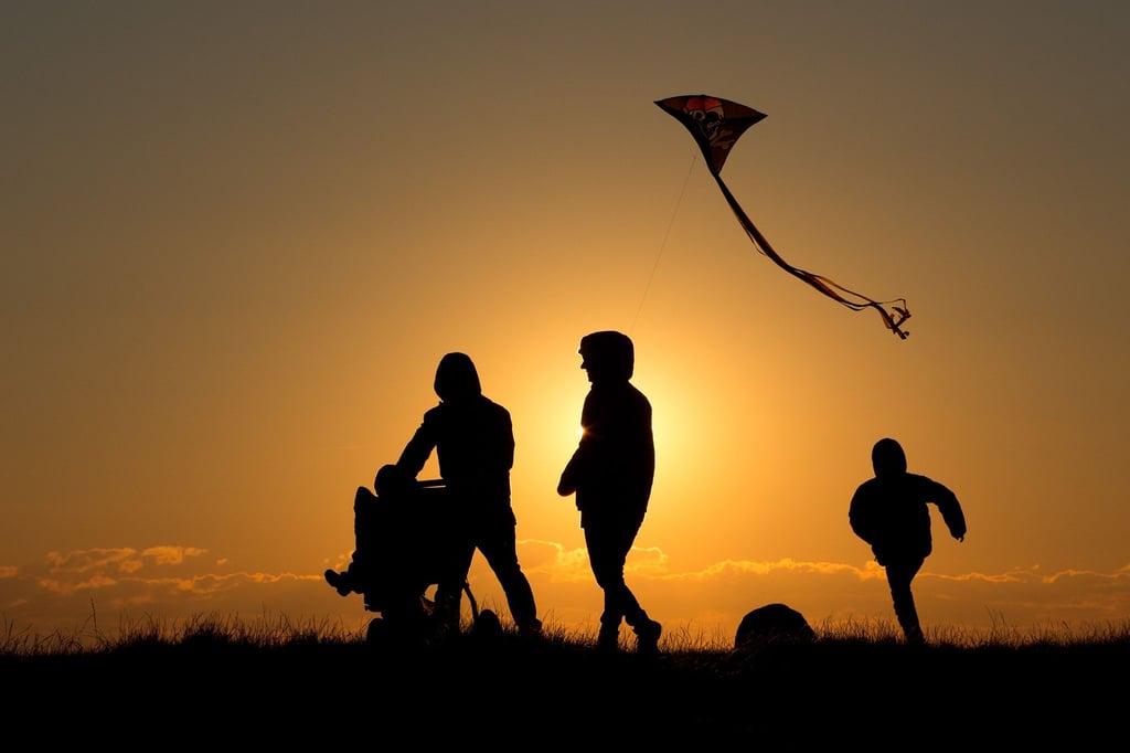 Eine Familie geht bei Sonnenuntergang über einen Weg.