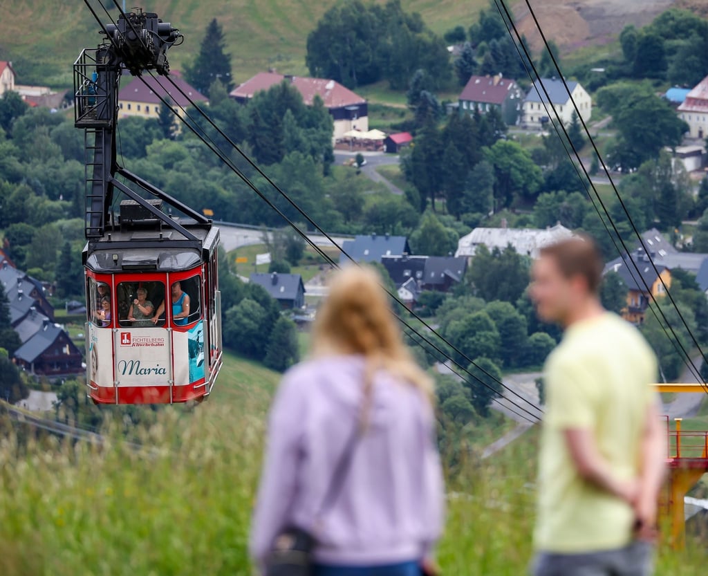 Zwei Spaziergänger beobachten die Ankunft der Fichtelbergschwebebahn an der Bergstation.