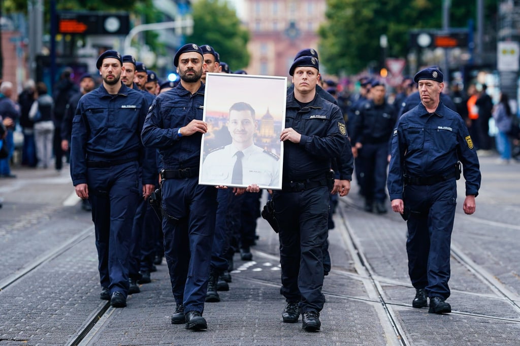 In Gedenken an ihren tödlich verletzten Kollegen Rouven Laur ziehen Polizisten durch die Mannheimer Innenstadt.