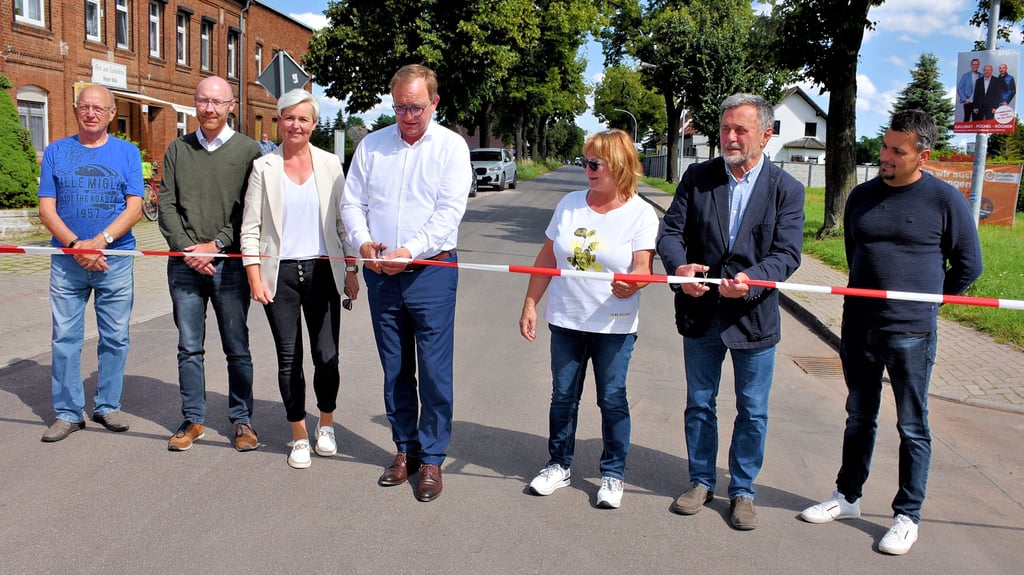 Landrat Markus Bauer (4. v.l.) und Bördeaue-Bürgermeister Peter Fries (2. v.r.) haben mit dem symbolischen Scherenschnitt die Ortsdurchfahrt Tarthun wieder für den Verkehr freigegeben.