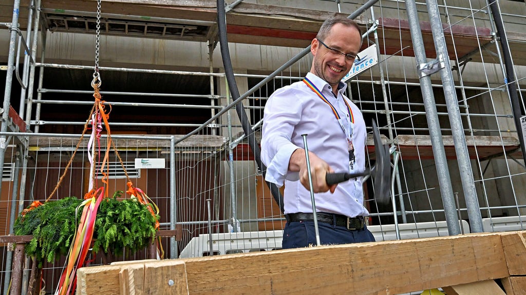 Mit deutschen Traditionen noch nicht so vertraut: Bauherr Alastair Wood müht sich beim Richtfest bei Cargill mit den großen Nägeln.