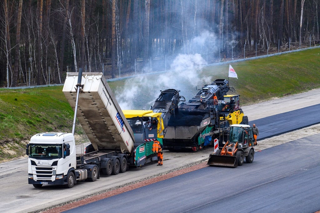 Arbeiter asphaltieren neue Abschnitte der Autobahn 14.