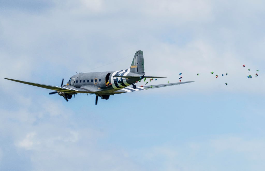Eine historische DC-3 wirft Süssigkeiten an Fallschirmen ab.