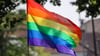 Eine Regenbogenfahne weht ei einem Umzug zum Christopher Street Day (CSD) im Wind.