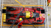 Mechaniker betanken das Auto des Teams Ferrari.