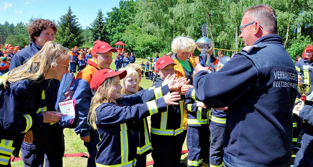 Große Freude bei der Jübarer Kinderfeuerwehr: Sie durfte den erstmal vergebenen Wanderpokal für den Sieg im Spiel ohne Grenzen mit nach Hause nehmen, den Andreas Klink (rechts) überreichte.