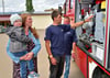 Susanne Wetzel und Sohn Elio lassen sich von Kevin Kuch (vorn) und Mathias Sieland die Technik in einem modernen Tanklöschfahrzeug erklären.