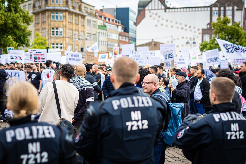 Polizisten beobachten zahlreiche Demonstranten.