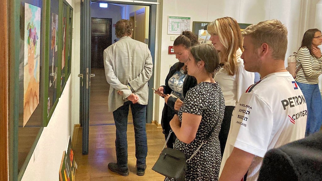 Im Rahmen der Vernissage im Coswiger Rathaus betrachten Schüler und Gäste die ausgestellten Werke intensiv.