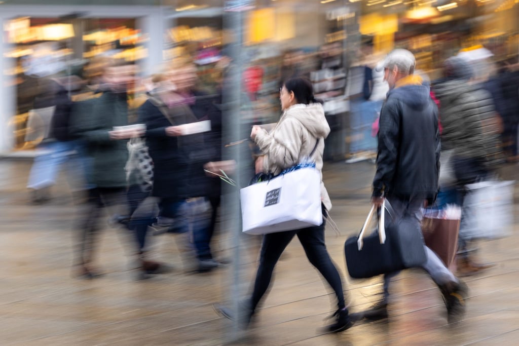Passanten sind in der Innenstadt zum Einkaufen unterwegs.
