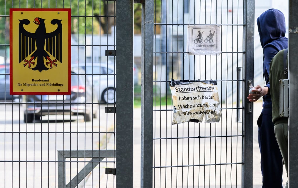 Ein Mann betritt neben einem Schild vom Bundesamt für Migration und Flüchtlinge die Landesaufnahmebehörde Niedersachsen am Standort Braunschweig.