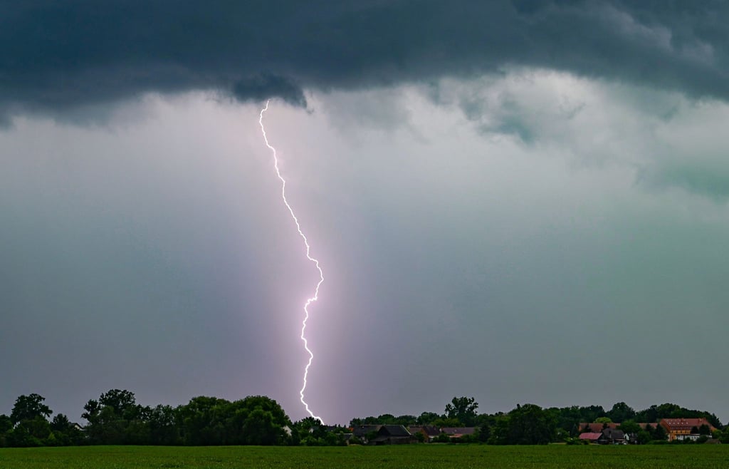 Ein Blitz leuchtet am späten Abend über der Landschaft im Landkreis Oder-Spree in Ostbrandenburg.