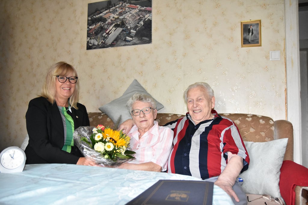Aufnahme von der Kronjuwelenhochzeit im Juli 2023: Helmut Kumbier legt den Arm um seine Hannelore. Oberbürgermeisterin Simone Borris gratulierte den Eheleuten.