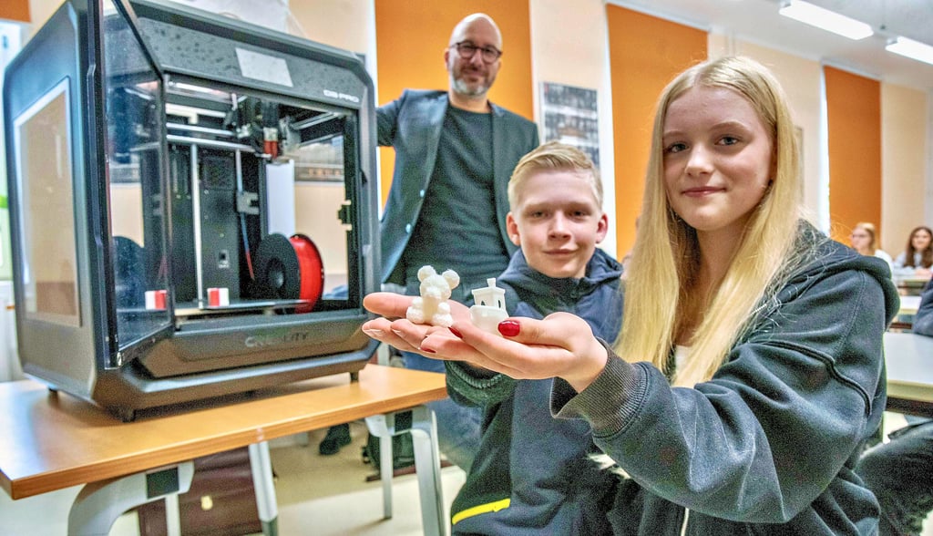 Die Freie Sekundarschule in der Dessauer Wasserwerkstraße hat einen 3D-Drucker für den Unterricht angeschafft. Felix Kellner und Samantha-Fraja Scholz zeigen die ersten gedruckten Objekte. Im Hintergrund ist Tobias Nelte von der Geschäftsleitung der Institut Braune gGmbH zu sehen.