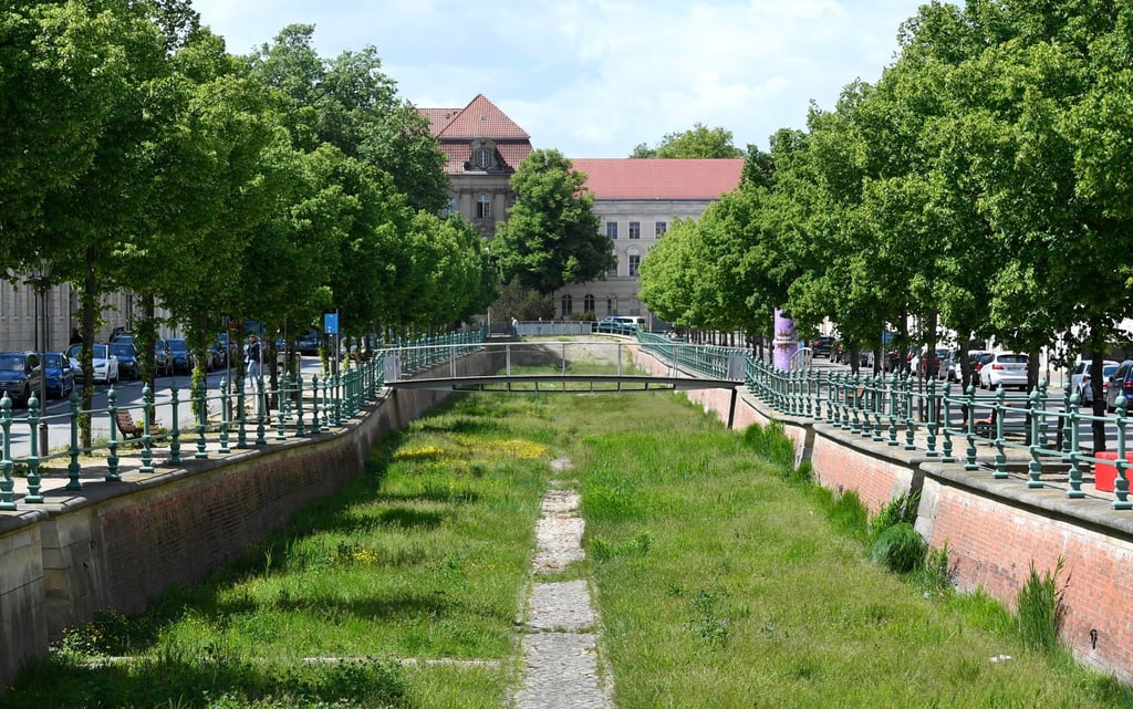 Der Boden des historischen Stadtkanals ist mit Kopfsteinpflaster bedeckt und mit Gras bewachsen.