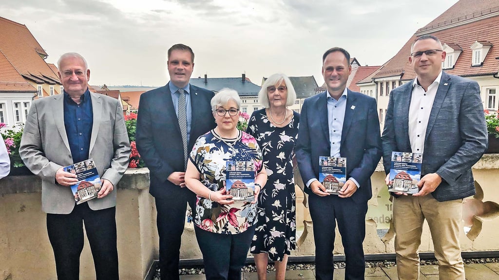 Fotograf Richard Bartlitz, Bürgermeister Carsten Staub, Vereinsvorsitzende Ute Klopfleisch, Autorin Rose-Marie Knape und die Geschäftsführer der Stadtwerke, Ronny Strebe, und der Wohnungsbaugesellschaft, Marc Reichardt (von links), präsentieren den neuen Stadtführer.