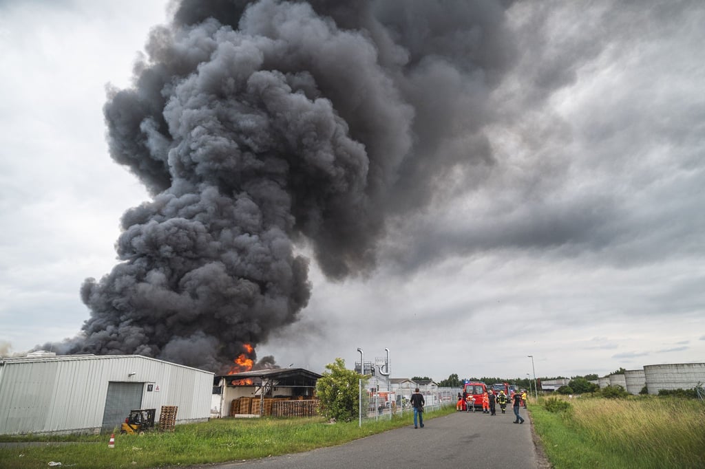 Schwarzer Rauch steigt beim Brand einer Lagerhalle in den Himmel.