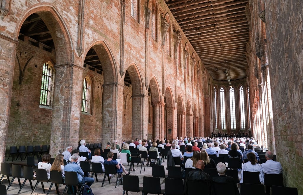 Gäste hören im Kloster Chorin beim 58. Choriner Musiksommer ein Konzert.