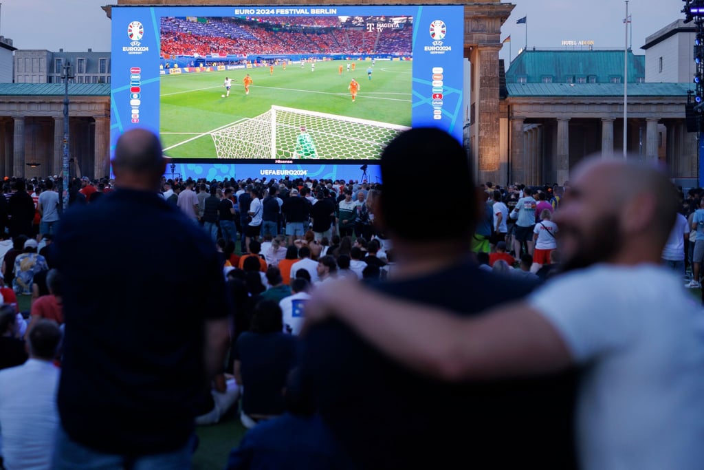 Besucher der FanZone verfolgen das Spiel beim Public Viewing am Brandenburger Tor.