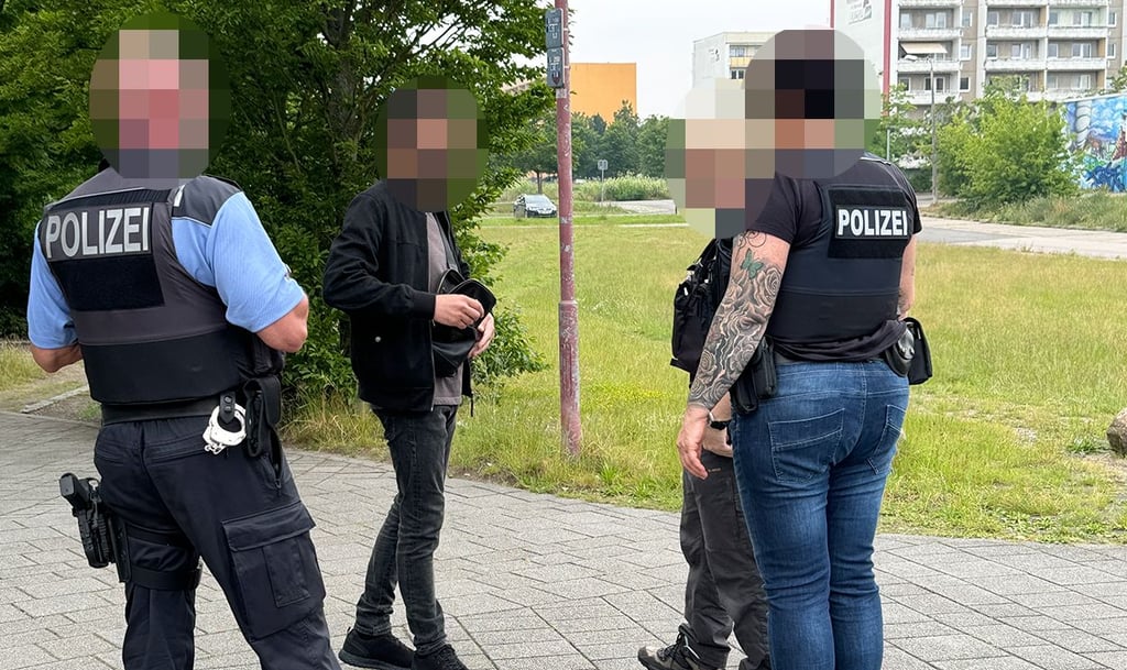 Beamte des Polizeireviers Stendal erklären einem Mann, was sie auf dem Platz hinter dem Altmarkforum kontrollieren.