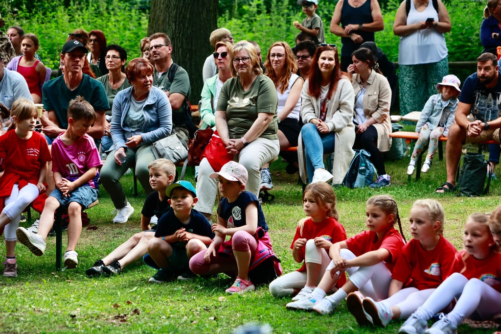 Vor der Bühne auf der kleinen Festwiese sitzen die Zuschauer.