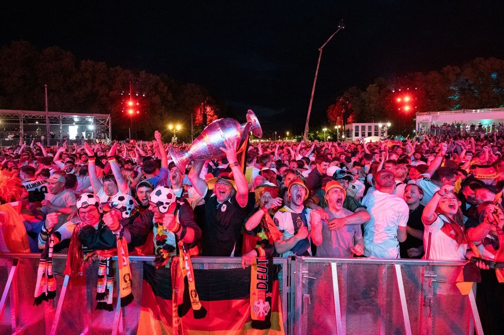 Fußballfans jubeln auf der Fanmeile vor dem Brandenburger Tor nach dem Ausgleich zum 1:1.