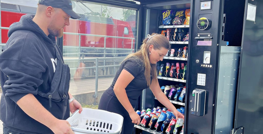 Louis und Lani Steinemann bestücken ihren Automaten neu (großes Bild). Direkt am Bahnhof, neben dem „LaLou Style“, steht ihr neues und wohl kleinstes Geschäft. von Tangerhütte. Das Logo (kleines Bild) wird noch an dem Automaten angebracht.