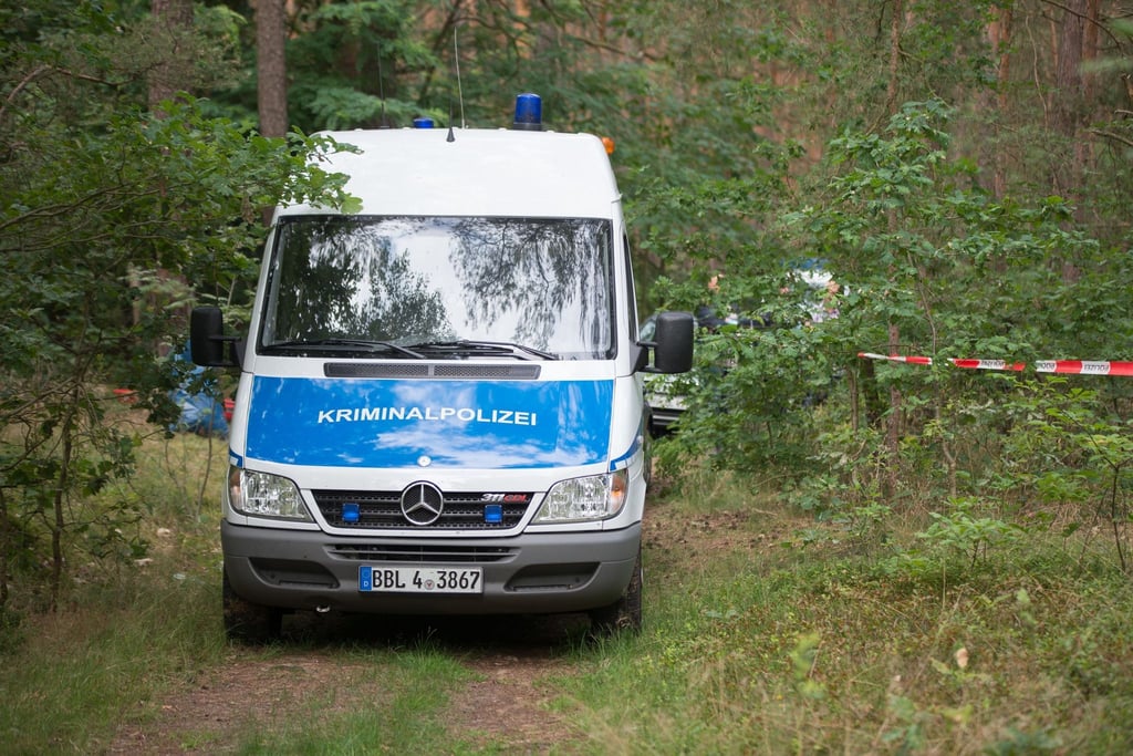 Ein Wagen der Kriminalpolizei steht in einem Wald bei Oranienburg.