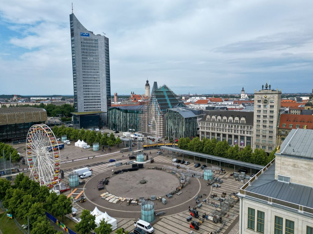 Arbeiter sind mit dem Aufbau der „Fan Zone“ für die Fußball-Europeisterschaft auf dem Leipziger Augustusplatz beschäftigt.wissen müssen“)