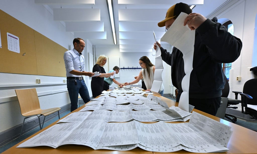 Wahlhelfer sortieren die Stimmzettel der Stichwahl und der Europawahl in einem Wahllokal in Erfurt.