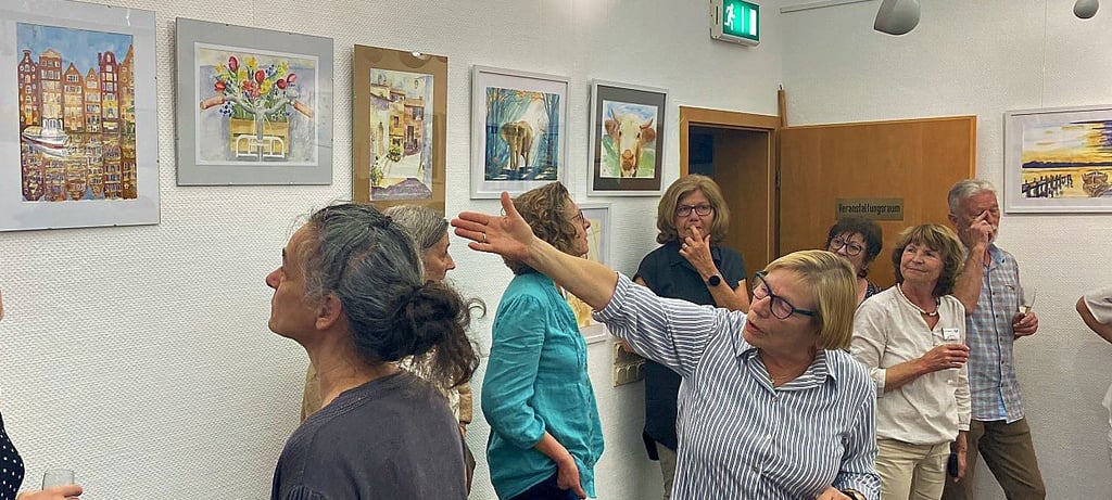 Catarina Stahlich zeigt ihre Aquarelle und erklärt den Besuchern das Konzept der Ausstellung.