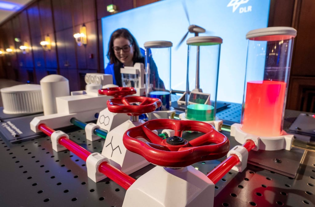 Eine Modellanlage, die die Auswirkung grüner Energie auf die Eigenschaften von Kerosin darstellt, demonstriert Doktorandin Marleen Schmidt auf einer Veranstaltung des Deutschen Zentrums für Luft- und Raumfahrt (DLR) im Chemiepark Leuna.