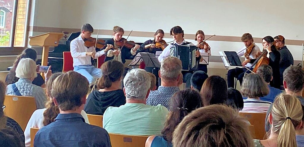 Zeugnisausgabe in der Kreismusikschule: Streicher musizieren mit Anton Kalle David am Akkordeon.