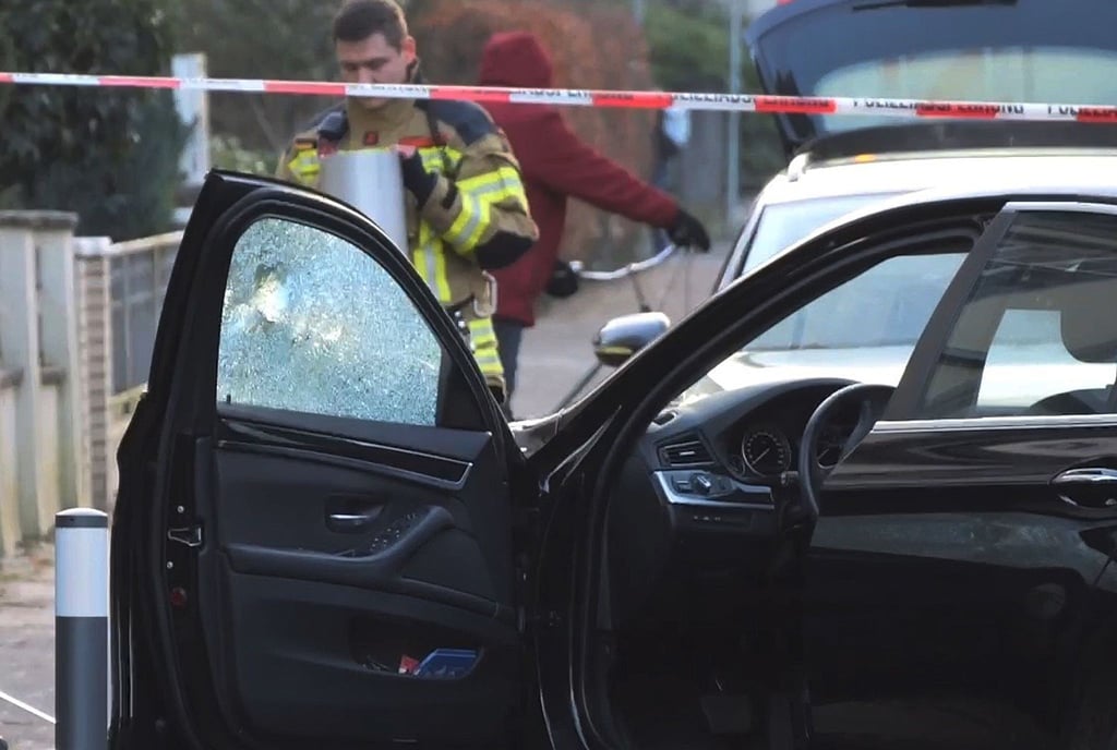 Ein Auto, an dem die Fensterscheibe ein Loch hat, wird untersucht.