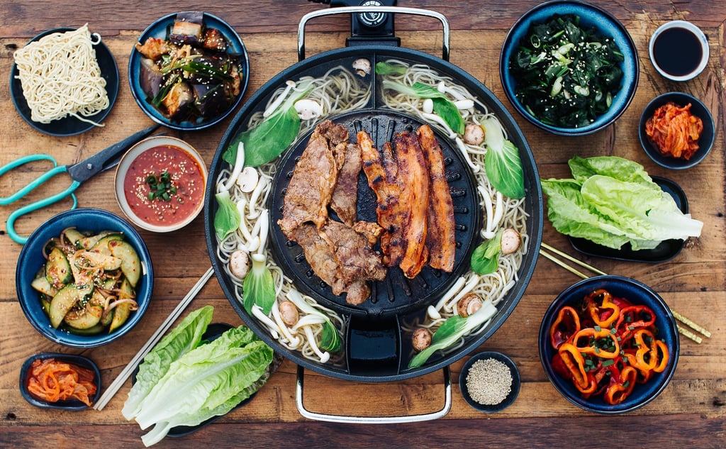 Koreanisches BBQ ist die beliebte Methode, Fleisch direkt am Esstisch zuzubereiten. Mariniertes Fleisch wird gegrillt, anschließend in ein Salatblatt gewickelt und in eine scharfe Sauce getunkt. Das genießt man zusammen mit verschiedenen Beilagen und Sauce zum Dippen.