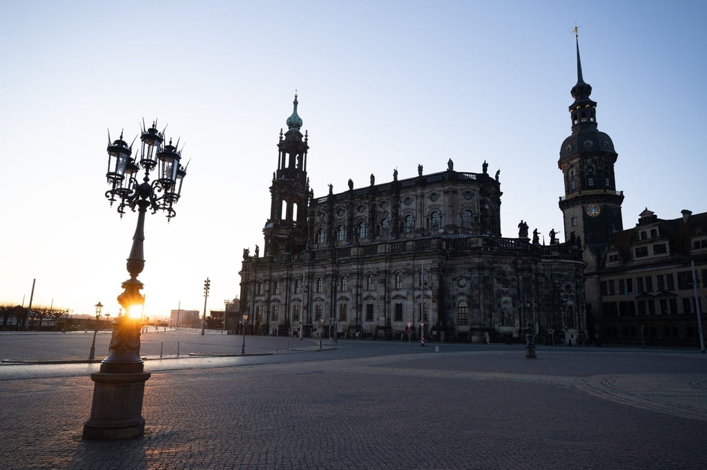 Der Theaterplatz mit der Katholischen Hofkirche (l) und dem Hausmannsturm bei Sonnenaufgang.
