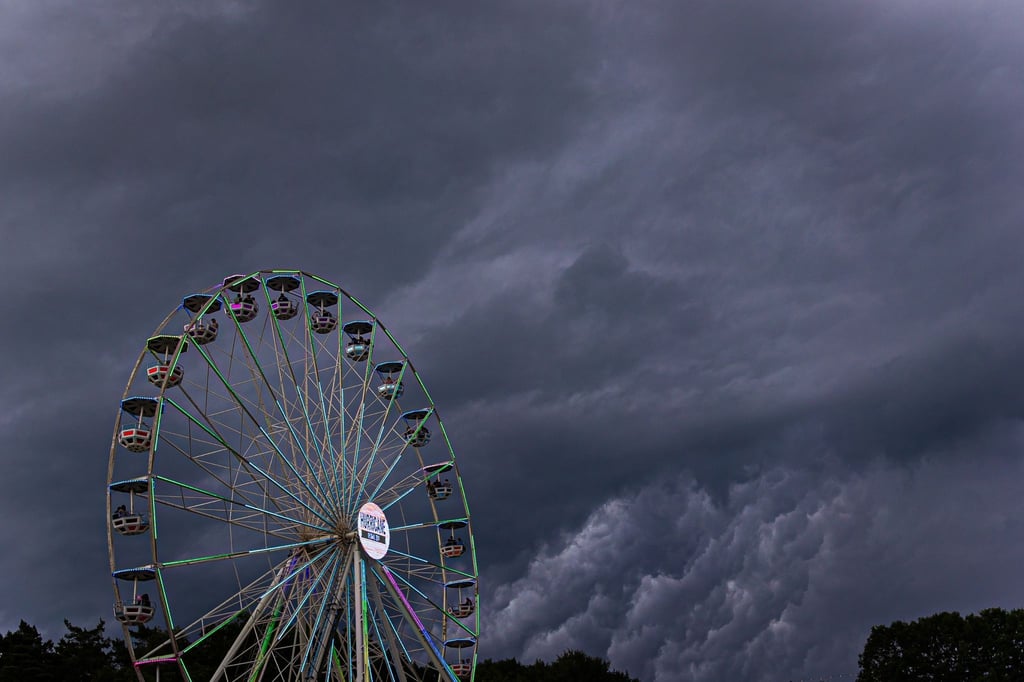 Dunkle Regenwolken ziehen über ein Riesenrad auf dem Gelände des Hurricane-Festivals in Scheeßel hinweg.