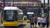Eine Straßenbahn der BVG steht an einer Haltestelle am Alexanderplatz, während im Hintergrund eine S-Bahn und eine Regionalbahn vorbeifahren.