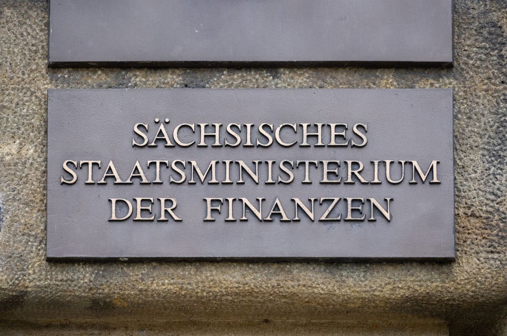 Ein Schild mit der Aufschrift "Sächsisches Staatsministerium der Finanzen" ist am Eingang des Gebäudes angebracht.