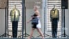 Eine Passantin gehen in einer Fußgängerzone an einem Schaufenster eines Modegeschäfts vorbei.